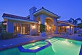 Illuminated swimming pool with Jacuzzi in front of luxury mansion Royalty Free Stock Photo