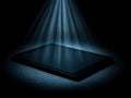 Illuminated tablet device casting a futuristic glow in a dark setting Royalty Free Stock Photo