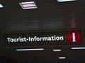 Illuminated tourist information sign with small crack mounted to the ceiling of a pedestrian passage in downtown in evening.