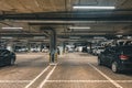 Illuminated underground car parking garage with lots of vehicles