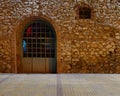 Illuminated vintage arched door and stone wall