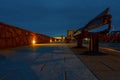 Illuminated walking path way at night and empty sitting bench. Warm and cool colors. Night scene Royalty Free Stock Photo