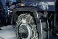 Illuminated wheel in the focus. Jeep with snow chains parked indoors at the white tile on vehicle show Royalty Free Stock Photo