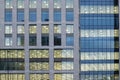 Illuminated windows on the facade of a large modern office building with lights turned on on at twilight Royalty Free Stock Photo