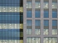 Illuminated windows on the facade of a large modern office building with lights turned on on at twilight Royalty Free Stock Photo