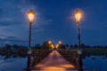 Illuminated wooden bridge over lake after sunset Royalty Free Stock Photo