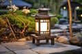 Illuminated Wooden Lantern in Tranquil Garden at Dusk Royalty Free Stock Photo