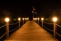 Illuminated wooden pier at night, lights on a wood bridge by the sea in Turkey. Seaside boardwalk with lanterns, round lamps. Royalty Free Stock Photo