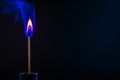 Illuminating Darkness A Single Matchstick Burnig with Blue and Orange Flames Royalty Free Stock Photo