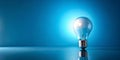 Illumination a single light bulb glowing brightly on a reflective surface against a vibrant blue background. Generative AI Royalty Free Stock Photo
