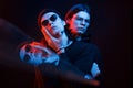 Illusion of three faces. Portrait of twin brothers. Studio shot in dark studio with neon light Royalty Free Stock Photo