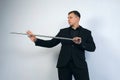 Magician man in black suit on show is showing trick with magic metal stick. Royalty Free Stock Photo