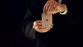 Illusionist showing ace of hearts in hands at camera, magic trick show, magician