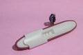 Illustration photo for Lovely moment, Young Couple Mini figure Toy kissing beyond Pregnancy test pack with positive result