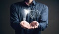 An illustrated hand touches a light bulb. Man holding in his hand