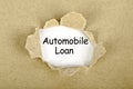 Automobile loan word written on a torn paper hole