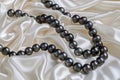 illustration of black pearls necklace on white satin background. Generative AI Royalty Free Stock Photo