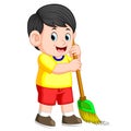 The boy with the black hair is sweeping the trash with the green broom