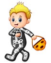 Boy in halloween skeleton costume with pumpkin basket