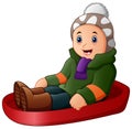 Cartoon boy in green winter clothes playing a sledge Royalty Free Stock Photo