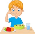 Cartoon little boy having breakfast cereals with fruits Royalty Free Stock Photo