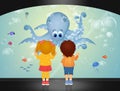 Children watch the octopus in the aquarium