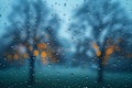 A closeup of raindrops on the window, with trees and sky in blurred focus outside. the rain is falling hard, creating an atmo Royalty Free Stock Photo