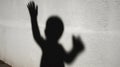 Illustration concept depicting the shadow of a child with a raised hands, symbolizing child abuse Royalty Free Stock Photo