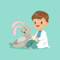 Cute baby boy heals paw of toy bunny. Little doctor and patient concept. Flat design vector illustration Royalty Free Stock Photo