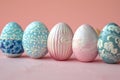 Depicting a row of easter eggs with blue and white patterns on the side, pink background, minimalist style, flat lay composit Royalty Free Stock Photo