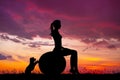 Girl does pilates at sunset with her puppy