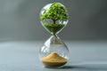 Hourglass with planet earth and tree inside on grey background, concept of time for environmental protection and climate chan Royalty Free Stock Photo