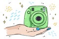 Illustration instant camera lies on the palm of your hand.