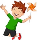 Little boy jumping with a paper windmill Royalty Free Stock Photo