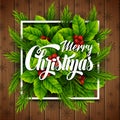 Merry christmas lettering card with pine branches and holly berry leaves over wooden background Royalty Free Stock Photo