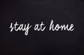Illustration with message to stay home written with chalk on a blackboard