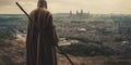 A hooded monk looking towards a modern city skyline Royalty Free Stock Photo