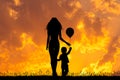 Mother and child with balloon at sunset