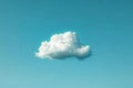 One white cloud floating in the sky against a solid blue background in a simple minimalistic style reminiscent of stop motion Royalty Free Stock Photo