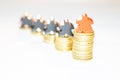Illustration of outperformance in economy with piles of ten cent coins and wooden meeples on white background Royalty Free Stock Photo