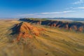 Panoramic photo of the massive multicolored m simulation mountain range in outback australia, vast flat plains below red and yell Royalty Free Stock Photo