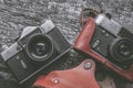 Illustration of retro film cameras in leather cases lying on a vintage wooden surface Royalty Free Stock Photo