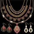 set of gold jewelry pendants necklaces on a chain and earrings with rubies and filigree