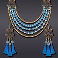 set of jewelry made of gold earrings and a necklace with precious stones and tassels Royalty Free Stock Photo