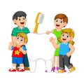 Smiling parents with two kids standing next to big white tooth holding toothbrush