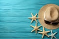 Illustration for summer vacation of a Hat, glasses, and starfish on a blue wooden background, in the style of serene seascapes.