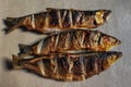 Three grilled milkfish on brown kraft paper