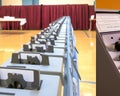 Illustration of voting machines in gymnasium with red curtain in background. AI Image