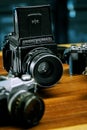 Illustrative editorial Close up shot of Mamiya RB67 medium format analog film camera and other cameras defocused on the background Royalty Free Stock Photo