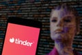 In this illustrative photo you can see the Tinder logo displayed on the screen of a smartphone with a blurred background of